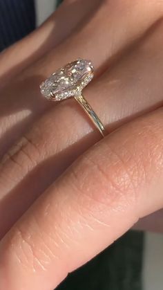 a close up of a person's hand with a diamond ring on their finger