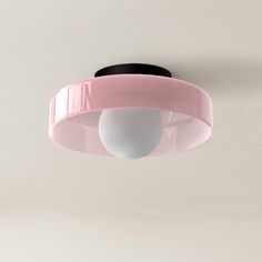 a pink ceiling light hanging from the ceiling