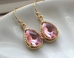 two pairs of pink earrings on a white plate