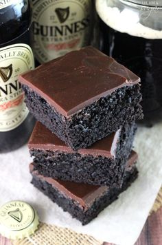 three brownies stacked on top of each other next to bottles of guinness and beer