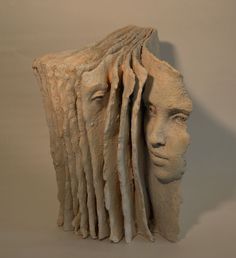 a sculpture of a woman's head with long hair