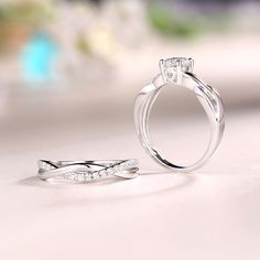 two wedding rings sitting next to each other on a table