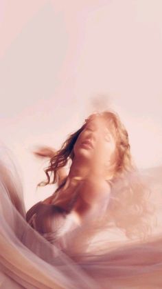 a blurry photo of a woman with her hair blowing in the wind and looking up