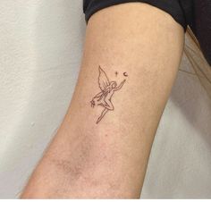 a small tattoo on the leg of a woman's left arm shows a fairy holding a wand