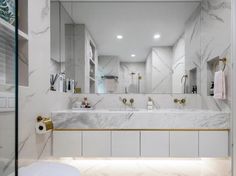 a bathroom with marble counter tops and gold fixtures