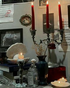 candles are lit on a table with books and other items