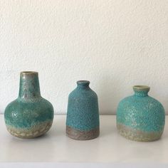 three vases sitting on top of a white table