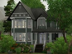 a large gray house surrounded by trees and flowers