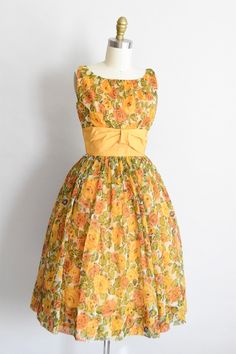 "Vintage 1950s cocktail dress. Nylon chiffon with autumnal floral print in yellow, orange, and green . Boat collar, nipped waist with wide contrasting yellow waistband with bow detail. Free skirt. Back metal zipper closure. Fully lined. State of garment | excellent. Measurements ✂--- Best fit | Extra small Bust | 34\" Shoulders | 13.5\" Shoulder to waist | 15\" Sleeves straps | 1 1/4\" Waist | snug 24\" Hips | free Total length (shoulder to hem) | 40.5\" Tag | none present ★★Visit The Shop★★ htt 1950s Style Yellow Dress For Garden Party, Yellow 1950s Style Dress For Garden Party, 1950s Style Yellow Dress For Vintage Fashion, Yellow 1950s Style Dress For Vintage Fashion, Vintage Orange Dress For Garden Party, Frock For Kids, Vintage Black Cocktail Dress, Vestidos Pin Up, Party Wear Frocks