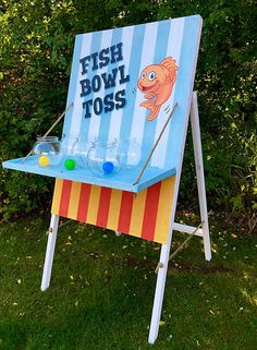 a fish bowl toss game in the grass