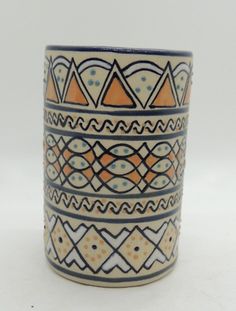 a ceramic cup with geometric designs on the outside and inside, sitting on a white surface