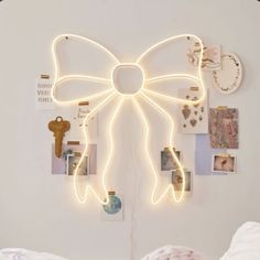 a white wall with many pictures on it and a lighted bow hanging from the ceiling