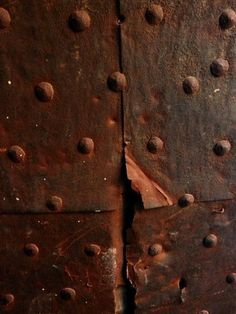 an old rusted metal surface with rivets and holes on it's sides