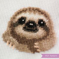 a close up of a cross stitch pattern of a slotty face on a white background