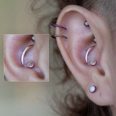 a woman's ear has three different piercings on it, including one in the middle