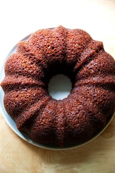 a bundt cake sitting on top of a white plate next to a wooden table