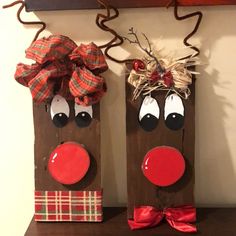 two wooden reindeers with red noses and bows on their heads are sitting on a shelf