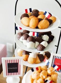 three tiered plates filled with desserts on top of a table