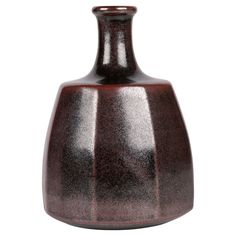 a brown vase sitting on top of a white table