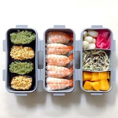 three plastic containers filled with food on top of a white table next to each other