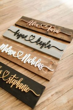 three wooden signs with names on them sitting on a table next to each other,