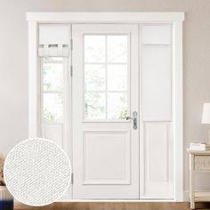 an open white door in a living room next to a table with a lamp on it