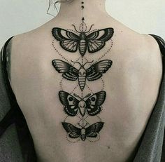 the back of a woman's neck with three butterflies and an owl on it