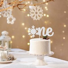 a white cake sitting on top of a table covered in snowflakes and frosting