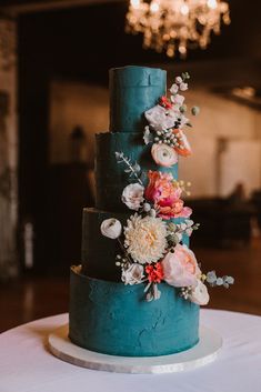 a three tiered blue cake with flowers on top