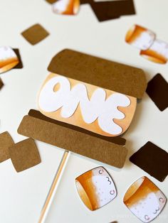 a paper cut out of the shape of a burger on a stick and some other items surrounding it