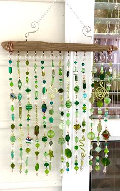 a wind chime hanging from the side of a window next to a shelf filled with glass beads