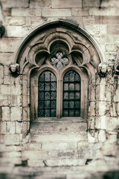 an old stone building with a large window