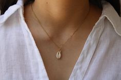 This minimalist necklace is perfect for the summer! D E T A I L S *It features a small white natural cowrie shell measuring around 10mm and a tiny stainless steel star fish charms that double as an evil eye amulet. *It is suspended from a sparkly 14k gold plated stainless steel chain *Stainless is does not tarnish and is also hypoallergenic. *It closes with a stainless steel clasp. C A R E * T I P You can wear this necklace on the beach or pool but always remember to rinse and dry it afterward. Avoid contact withperfume and body lotion. Also remove when exercising or sleeping. P A C K A G I N G: All our products are gift ready. T E R M S* O F* S A L E S & F A Q https://etsy.me/2PuWBv6 F O L L O W Instagram: @Allaboutevecreations and  Facebook: www.facebook.com/AllAboutEveCreations Pinteres White Shell Charm Necklace Gift, White Shell Charm Necklaces, White Summer Charm Necklace For Vacation, White Summer Vacation Charm Necklaces, Summer Vacation White Charm Necklaces, White Shell Jewelry With Starfish Charm, Dainty White Shell Necklace, White Starfish Shell Necklace As A Gift, White Starfish Shell Necklace With Starfish Charm