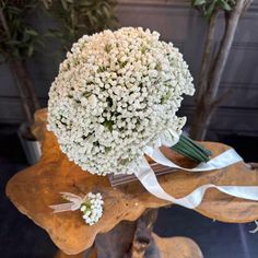 a bouquet of white flowers sitting on top of a wooden table