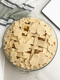 a pie sitting on top of a table next to a laptop