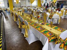 the tables are decorated with yellow and white cloths, gold ribbon sashes, and balloons