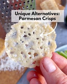 a person holding up a piece of bread with the words unique alternatives parmesan crispes