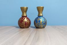 two vases sitting on top of a wooden table