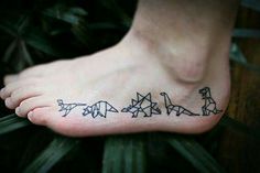 a person has a tattoo on their foot that shows three dinosaurs and one is in the shape of an origami