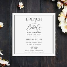 the brunch and baby shower is shown on top of a wooden table with flowers