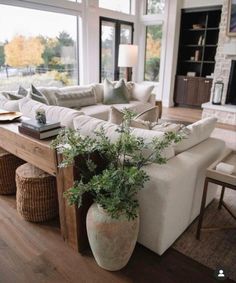 a living room filled with furniture and a large window covered in lots of natural light