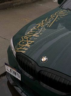 a car parked on the side of the road with graffiti written on it's hood