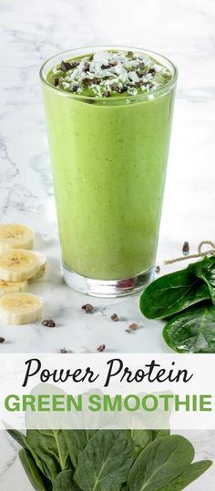 green smoothie in a glass with bananas and spinach on the side, next to it