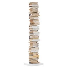 a tall stack of books sitting on top of a white pedestal