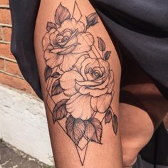 a black and white rose tattoo on the leg