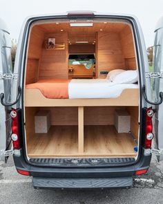 the back end of a van with an open bed and storage compartment on it's side