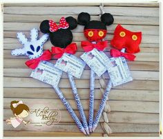 mickey mouse and minnie mouse hair clips with red bows on them, sitting next to each other