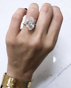 a woman's hand with a ring on it and a diamond in the middle