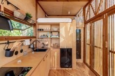 the interior of a tiny cabin with wood flooring and walls that have glass doors