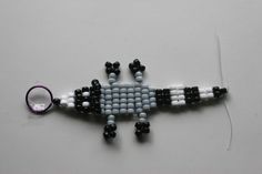 an ornament made to look like a lizard with black and white beads on it